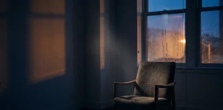 Mental Health im Business: Das Tabu, das Gründer zerstört Leerer Sessel in einem abgedunkelten Raum vor einem regennassen Fenster in der Dämmerung – Sinnbild für psychische Belastung und Isolation von Gründerinnen und Gründern
