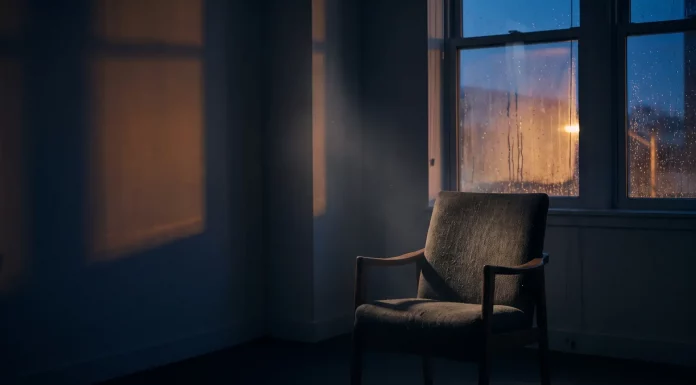 Mental Health im Business: Das Tabu, das Gründer zerstört Leerer Sessel in einem abgedunkelten Raum vor einem regennassen Fenster in der Dämmerung – Sinnbild für psychische Belastung und Isolation von Gründerinnen und Gründern