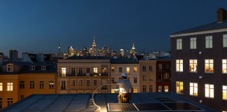 100 Millionen Dollar Kredit statt Series B: Wie Cloover mit 301 Millionen Umsatz profitabel wurde Anonymer Installateur montiert bei Dämmerung ein Photovoltaikmodul auf einem Berliner Altbaudach, im Hintergrund beleuchtete Wohnhäuser